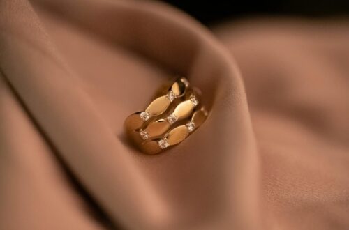 Luxurious gold ring featuring diamonds, delicately resting on a soft fabric, exuding elegance and sophistication.